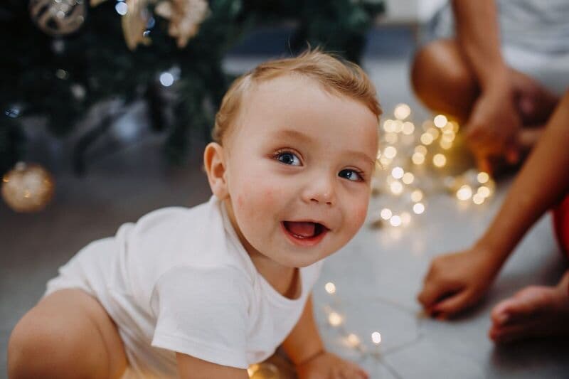 Adorabile bambino che si gode le luci festive al chiuso, catturando momenti gioiosi e carini.