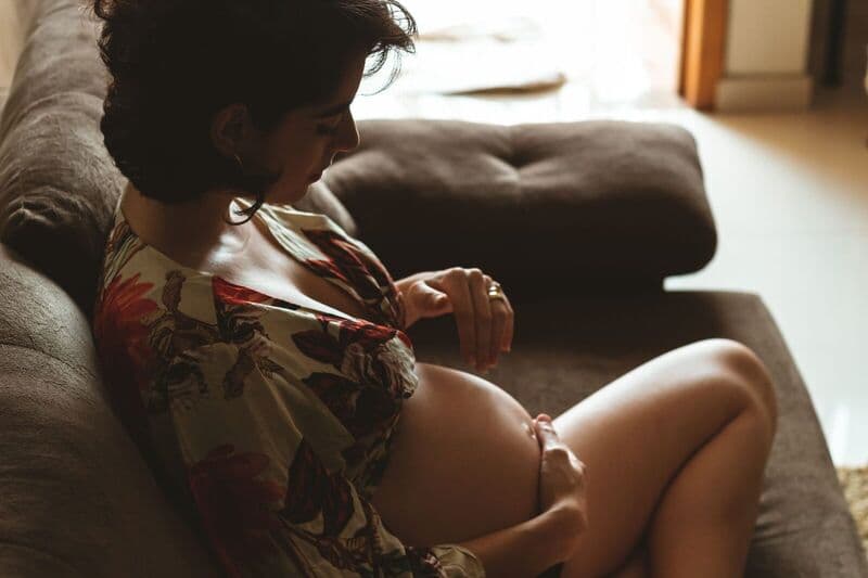 Una donna incinta si gode un momento di tranquillità su un comodo divano.