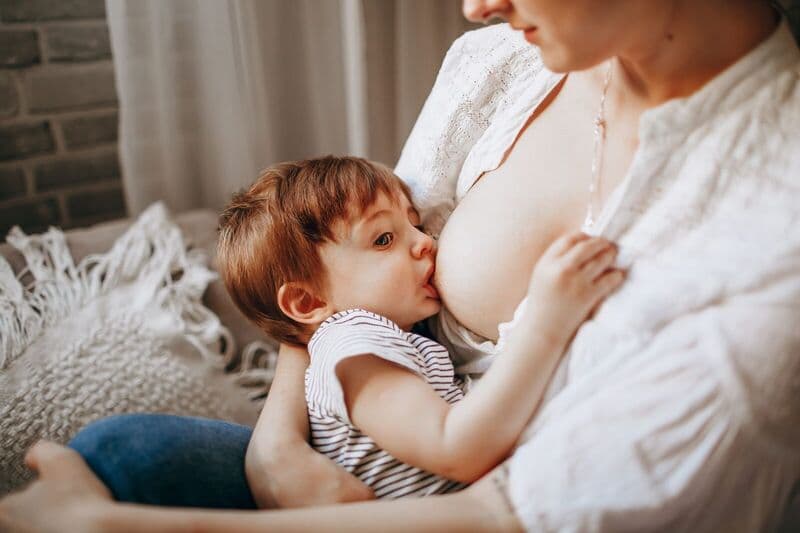 Un momento tenero di una madre che allatta il suo bambino, evidenziando amore e cura.