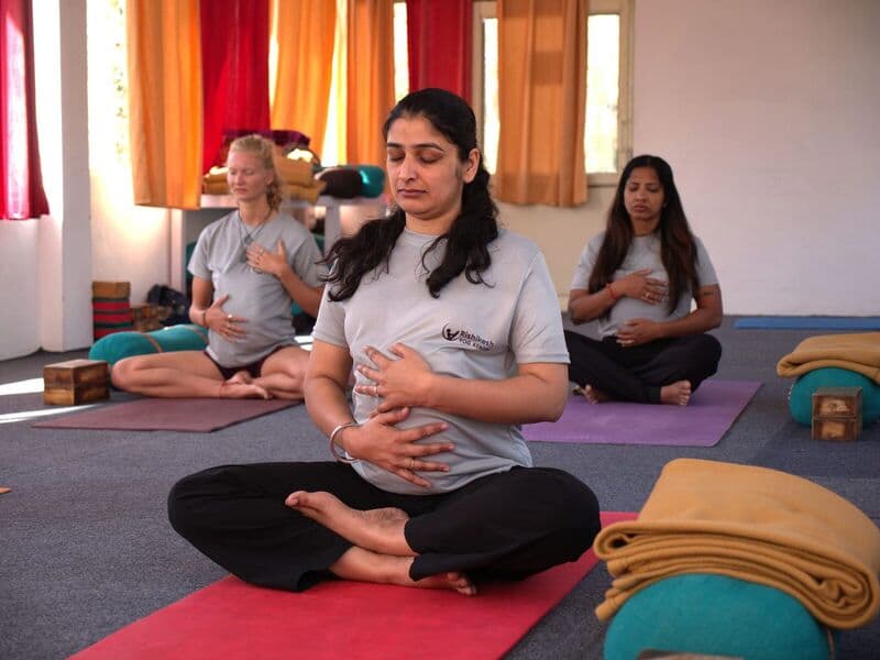 Donne incinte praticano yoga prenatale rilassante in uno studio tranquillo.