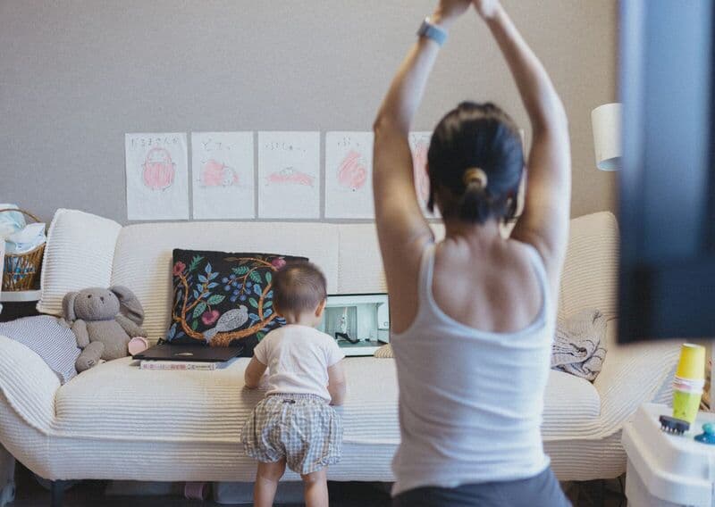 Una madre e suo figlio praticano yoga a casa, migliorando il benessere e rafforzando il legame familiare.