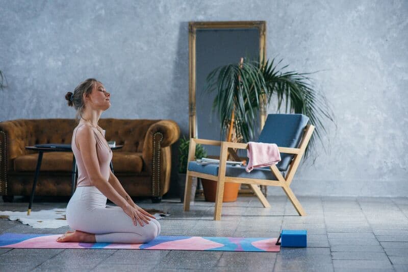 Una donna medita in un ambiente interno tranquillo, promuovendo il benessere e uno stile di vita sano.